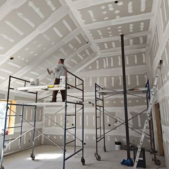 scaffolding with drywall taper working on it